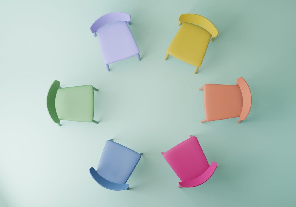 Stuhlkreis mit bunten Stühlen – Symbol für Gruppen- und Teamsupervision